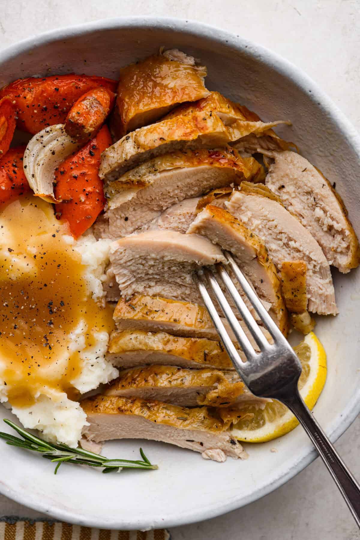 When you dry brine your turkey, you end up with a beautifully browned bird with crispy skin on the outside and juicy, flavorful meat on the inside! It will for sure be one of the most flavorful, moist turkeys you've ever had! Overhead shot of plated dry brine. turkey with a side of mashed potatoes and gravy, and roasted vegetables.