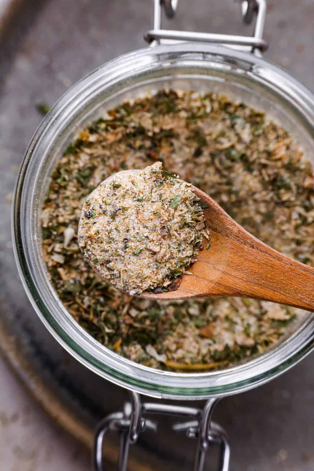 Homemade garlic herb seasoning is a great mix to have on hand. It has multiple uses, is full of flavor, and is adjustable to suit your taste preferences. It has the perfect mix of herbaceous dried herbs, garlic, onion powder, salt, and fresh cracked pepper. Close up shot of a spoonful of homemade garlic herb seasoning.