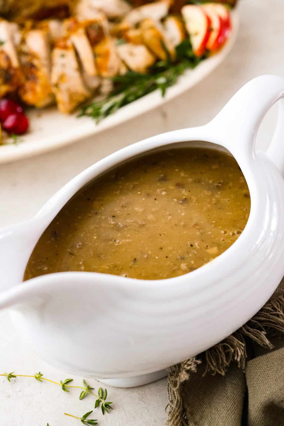 Giblet gravy is a labor of love, but the flavor is unmatched! Using the turkey's neck, gizzard, heart, liver, and drippings, you can make the best gravy you've ever had! It will be the perfect complement to your holiday turkey dinner. Angle shot of giblet gravy in a gravy boat.