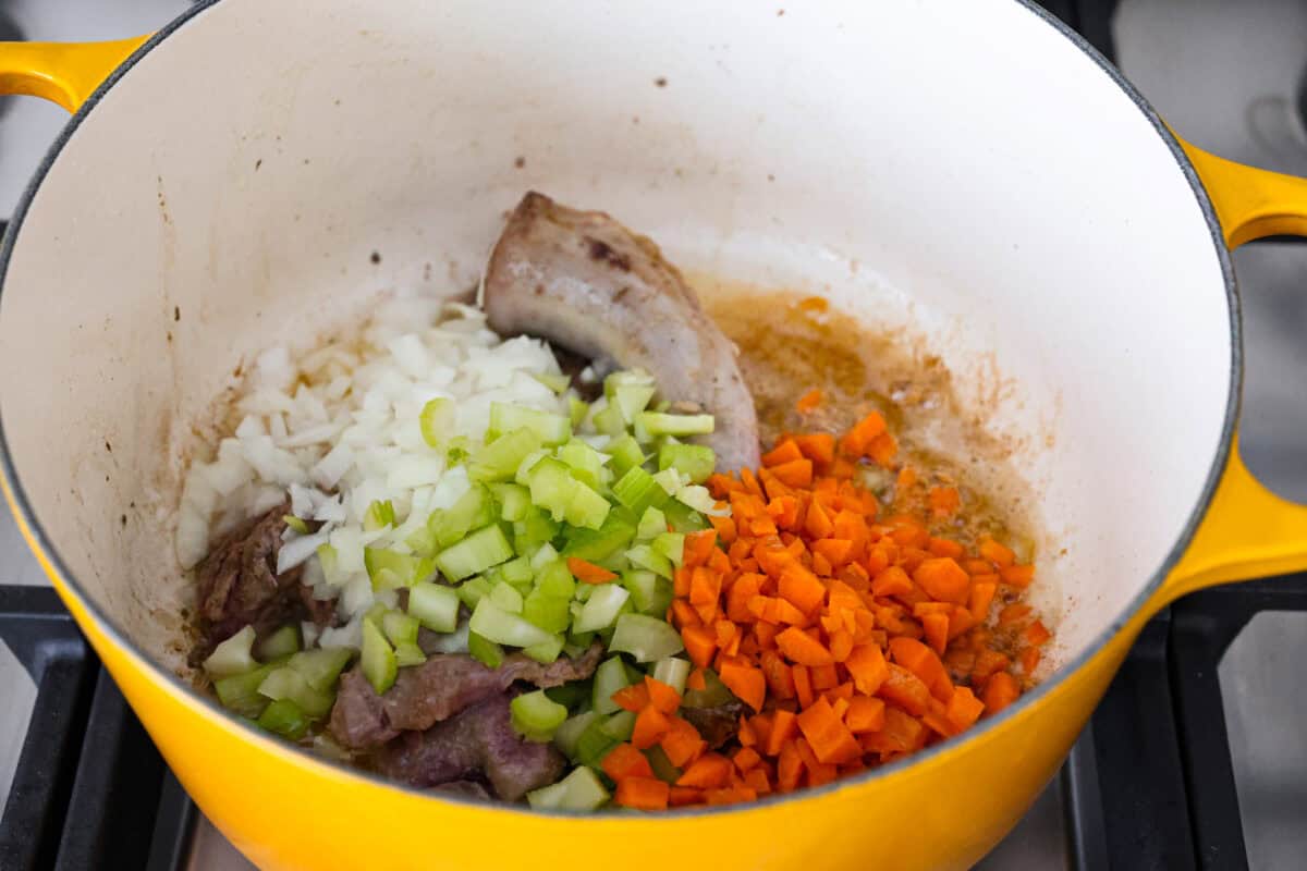 Giblet gravy is a labor of love, but the flavor is unmatched! Using the turkey's neck, gizzard, heart, liver, and drippings, you can make the best gravy you've ever had! It will be the perfect complement to your holiday turkey dinner. Angle shot of celery, carrots and onions in the pot with cooking giblets.