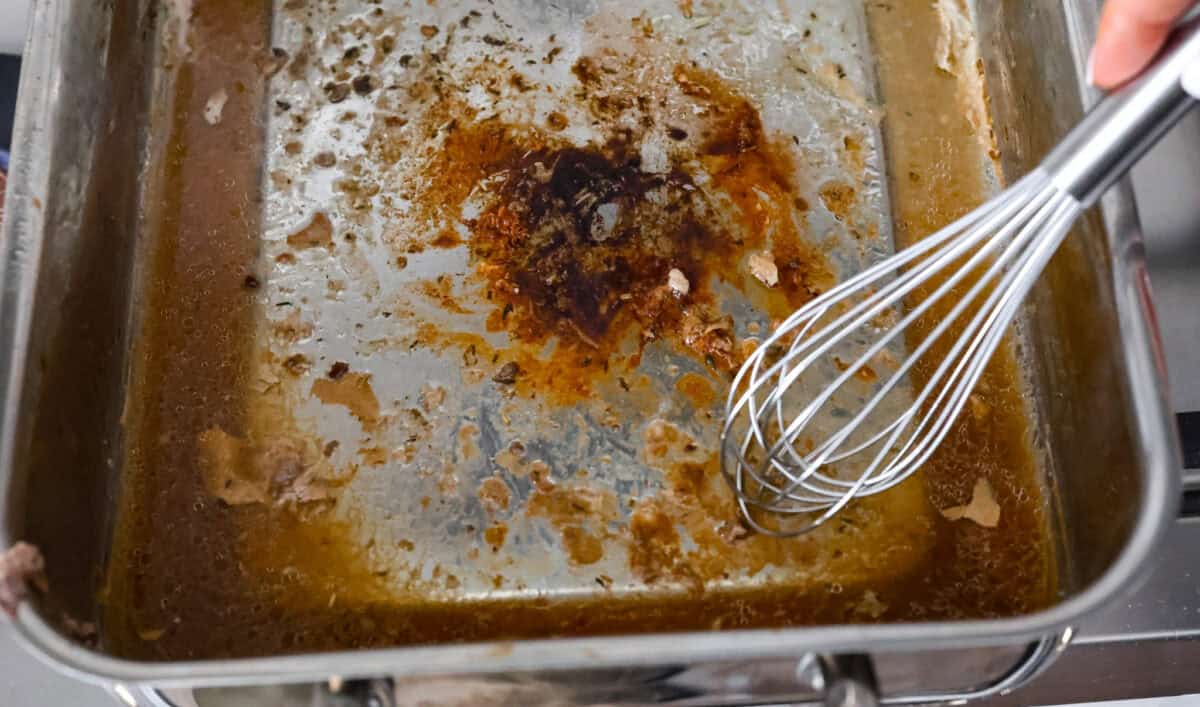 Giblet gravy is a labor of love, but the flavor is unmatched! Using the turkey's neck, gizzard, heart, liver, and drippings, you can make the best gravy you've ever had! It will be the perfect complement to your holiday turkey dinner. Overhead shot of deglazing the drippings from the turkey pan.