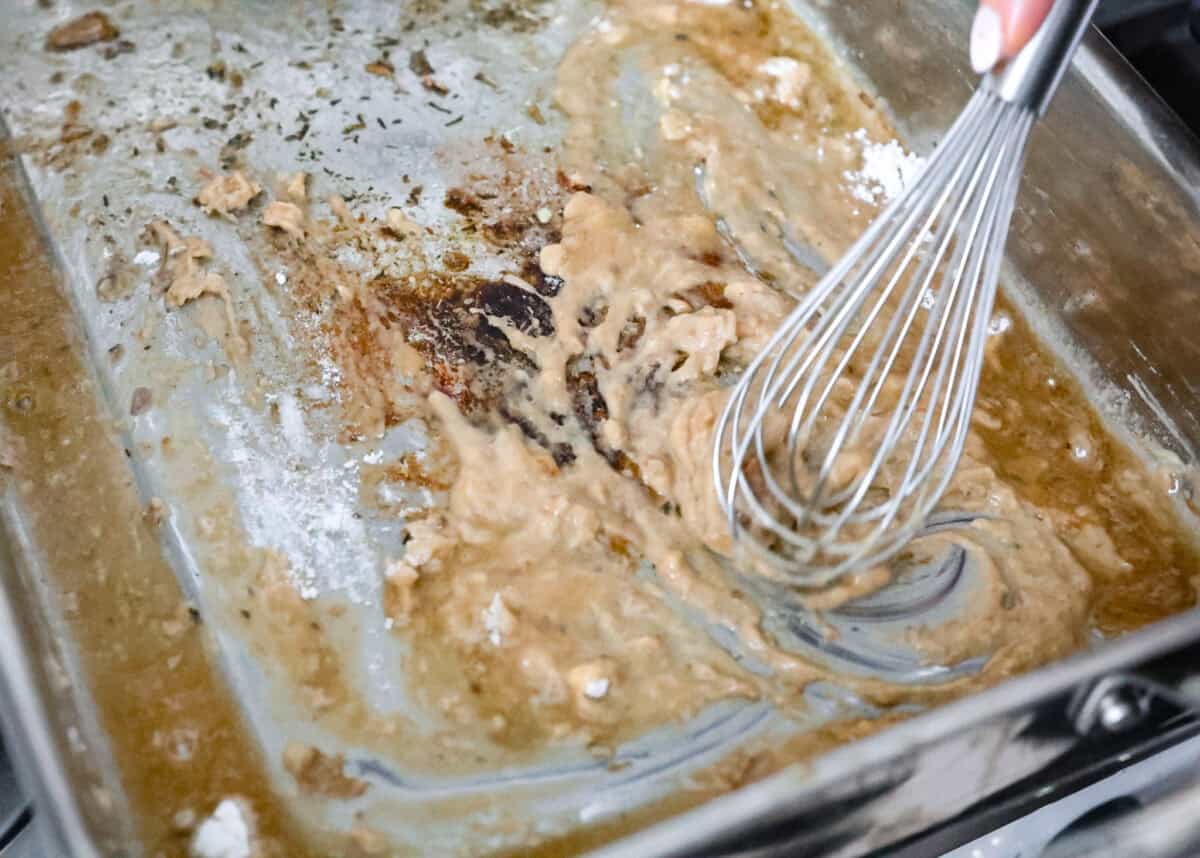 Giblet gravy is a labor of love, but the flavor is unmatched! Using the turkey's neck, gizzard, heart, liver, and drippings, you can make the best gravy you've ever had! It will be the perfect complement to your holiday turkey dinner. Angle shot of someone whisking flour into the drippings.