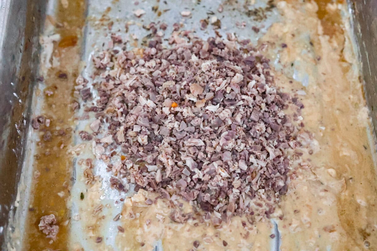 Giblet gravy is a labor of love, but the flavor is unmatched! Using the turkey's neck, gizzard, heart, liver, and drippings, you can make the best gravy you've ever had! It will be the perfect complement to your holiday turkey dinner. Angle shot of finely diced giblet pieces in the pan with flour an drippings.