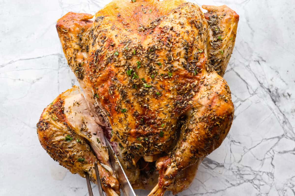 Learning how to carve a turkey is easier than you think! My step-by-step tutorial is here to help you along the way. Impress your guests with your beautifully carved turkey. First photo of a knife cutting into a turkey leg.