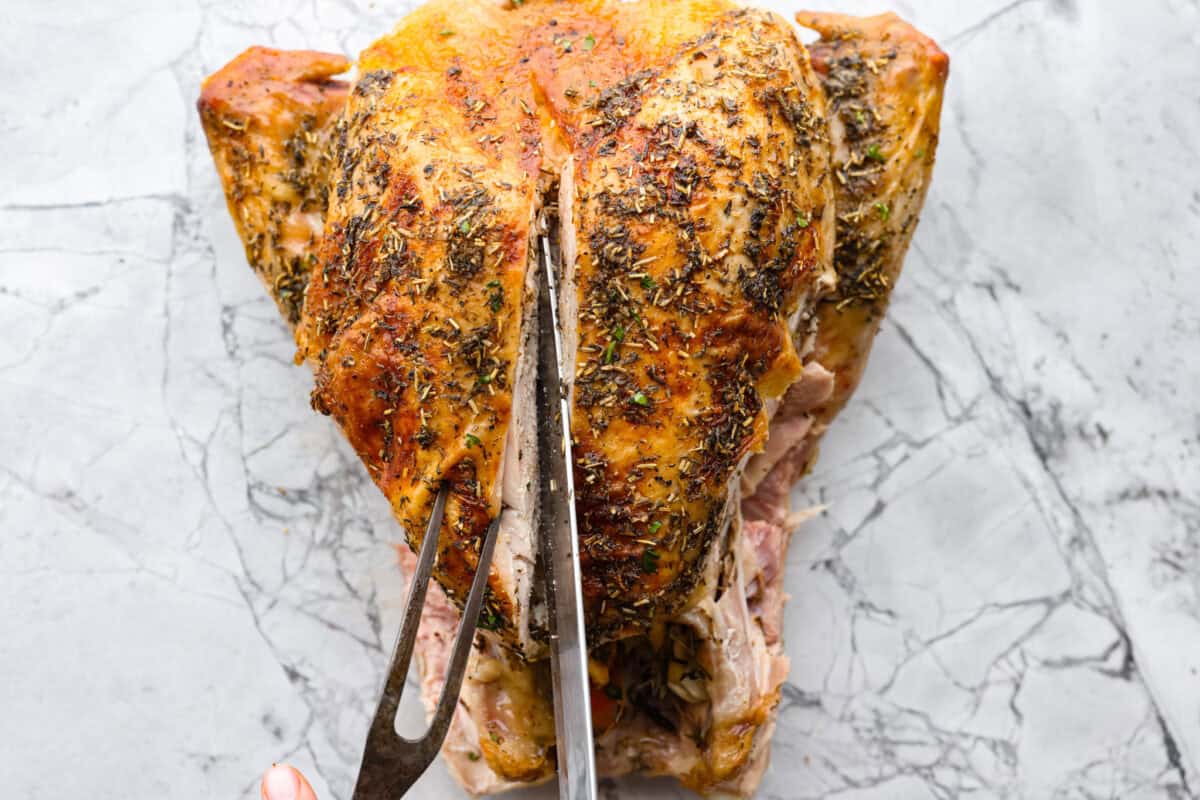 Learning how to carve a turkey is easier than you think! My step-by-step tutorial is here to help you along the way. Impress your guests with your beautifully carved turkey. Third photo of the knife carving into the breast.