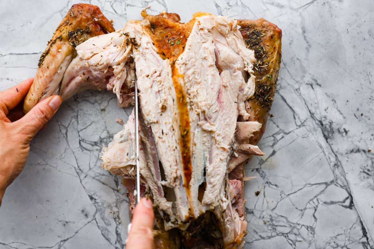 Learning how to carve a turkey is easier than you think! My step-by-step tutorial is here to help you along the way. Impress your guests with your beautifully carved turkey. Seventh photo of the knife cutting off the wing.