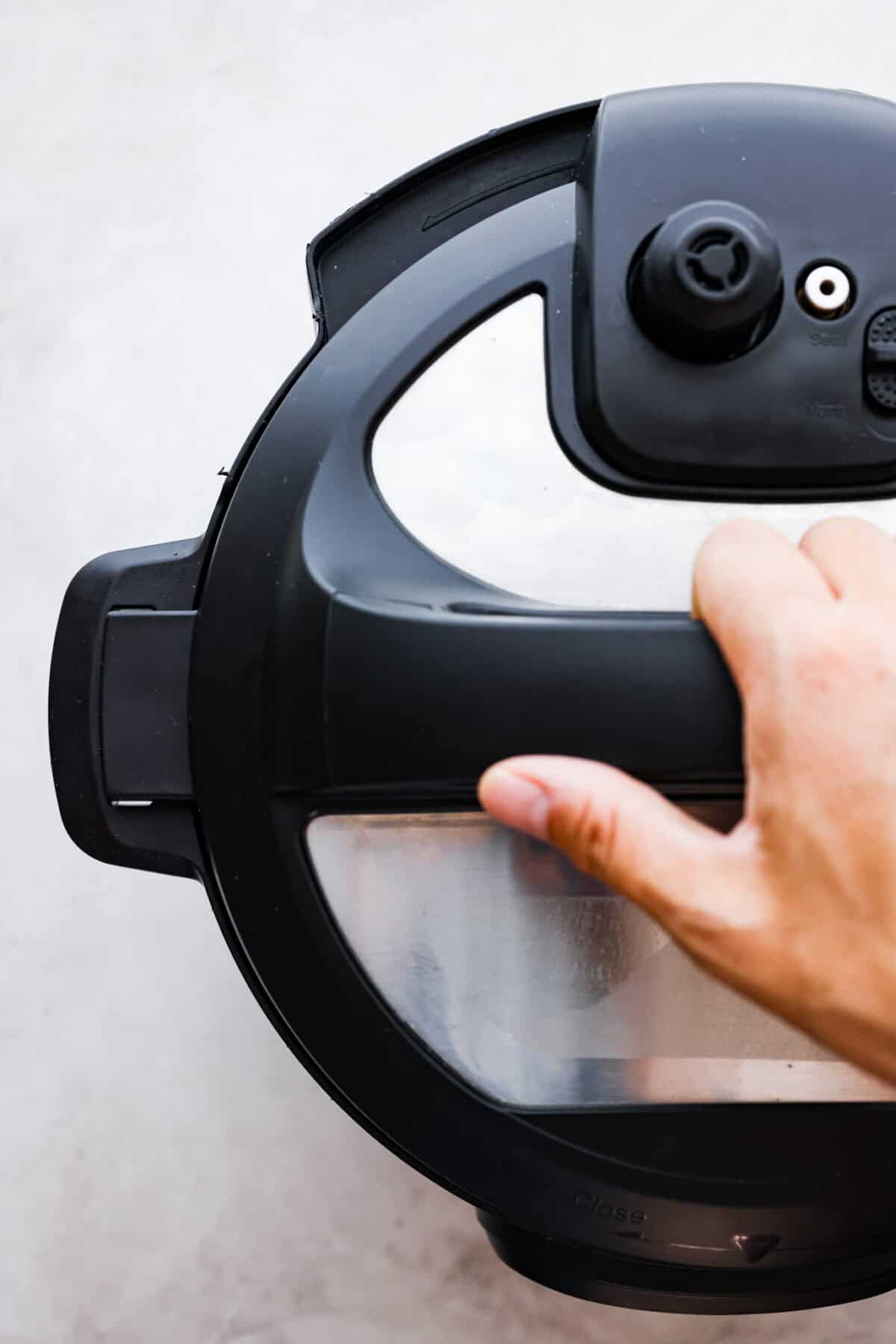 STOP being scared of your Instant Pot! This beginner's guide on How to Use an Instant Pot will help you feel comfortable and confident when using this magical kitchen appliance. It makes cooking fast, easy, and convenient. Second photo of the lid locking in place on an Instant Pot.