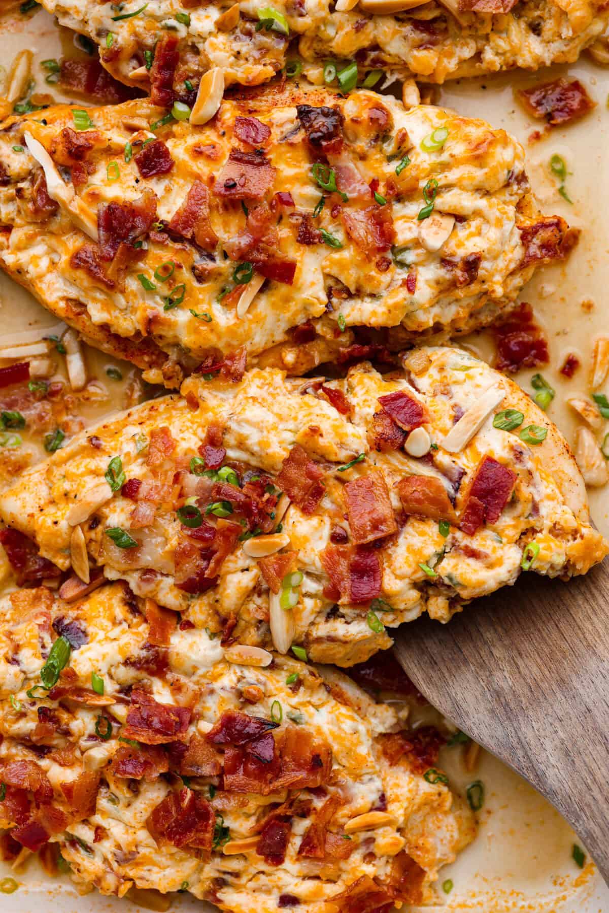 Million Dollar Chicken features juicy baked chicken topped with a creamy, cheesy layer that’s bursting with flavor. The crispy bacon and crunchy almonds really take this to the next level. Enjoy with rice, pasta, vegetables, or any of your favorite sides! Close up shot of million dollar chicken.