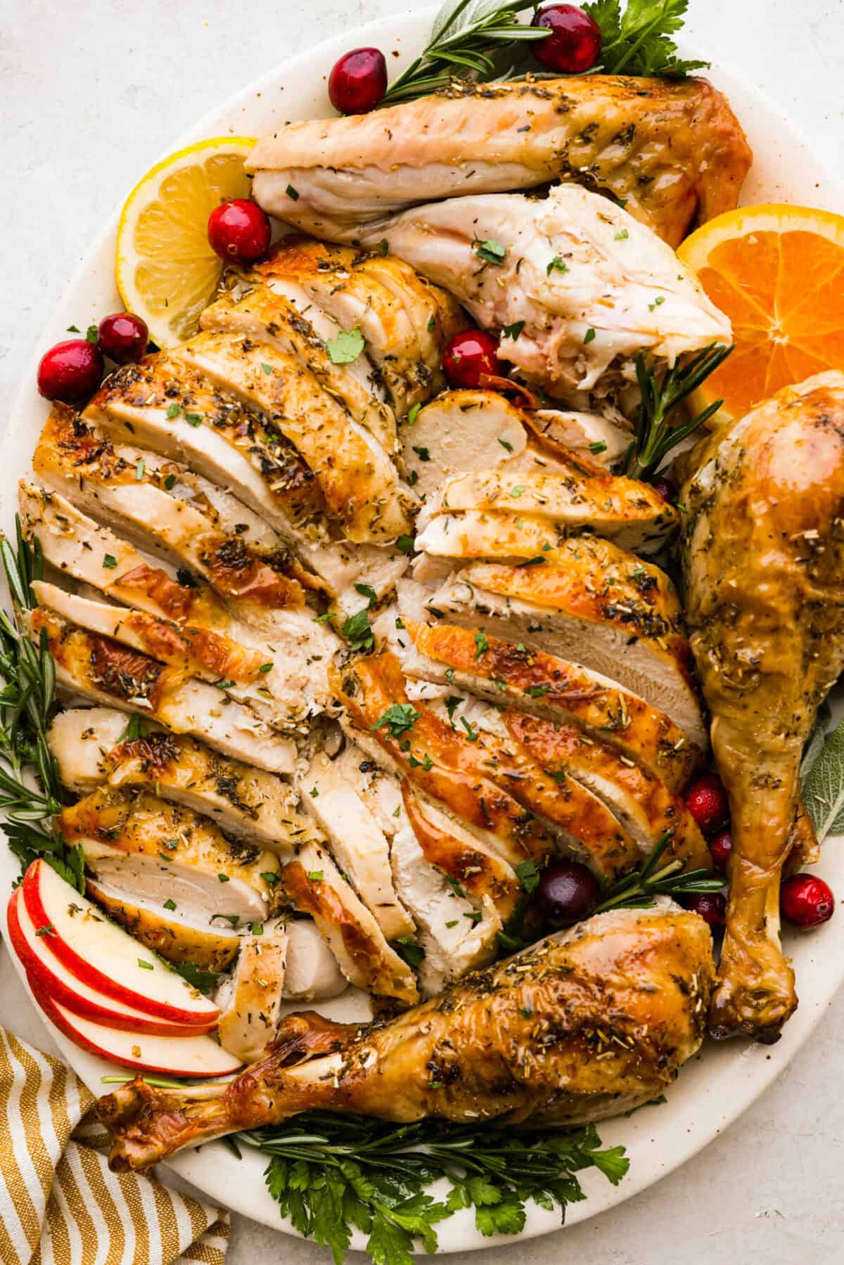 Look no further! This roasted turkey recipe is the absolute juiciest, fool-proof turkey recipe you will ever need. You'll have the confidence to make a perfect turkey every time. This deliciously seasoned turkey will be the star of your Thanksgiving meal! Top view of the carved oven roasted turkey on a platter.