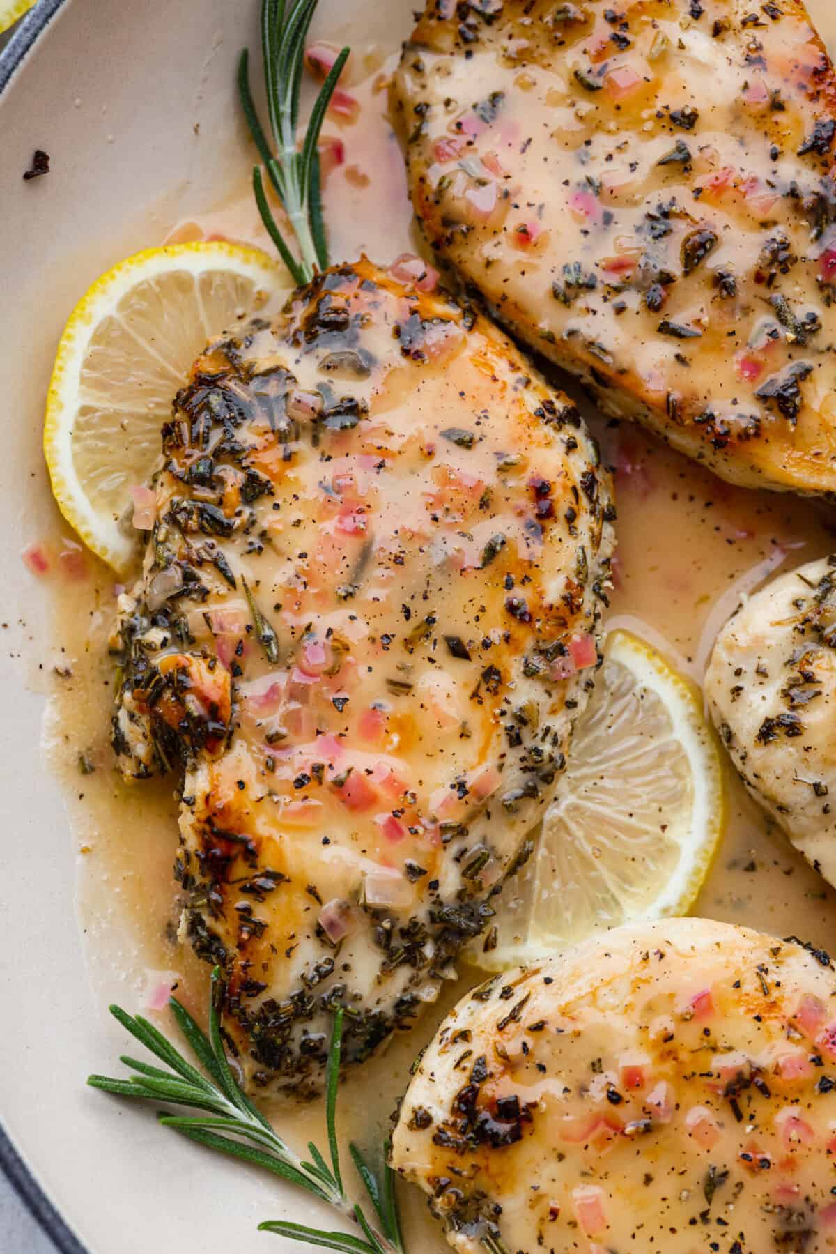 Rosemary Chicken is an incredibly simple yet flavorful dish you can whip up in no time. The infusion of butter with savory shallots, bright lemon juice, fresh rosemary, and tender seared chicken is an explosion of flavor. Close up shot of rosemary chicken.