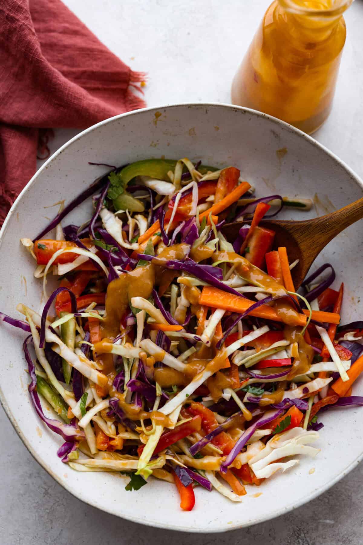Thai peanut dressing is perfect for drizzling over fresh chopped salads or dipping veggies. It's a creamy mix of peanut butter, soy sauce, lime juice, and sweet chili sauce with a touch of garlic and ginger. Itโs nutty and tangy, with the perfect amount of spice. Overhead shot of a Thai salad with Thai peanut dressing drizzled over the top.