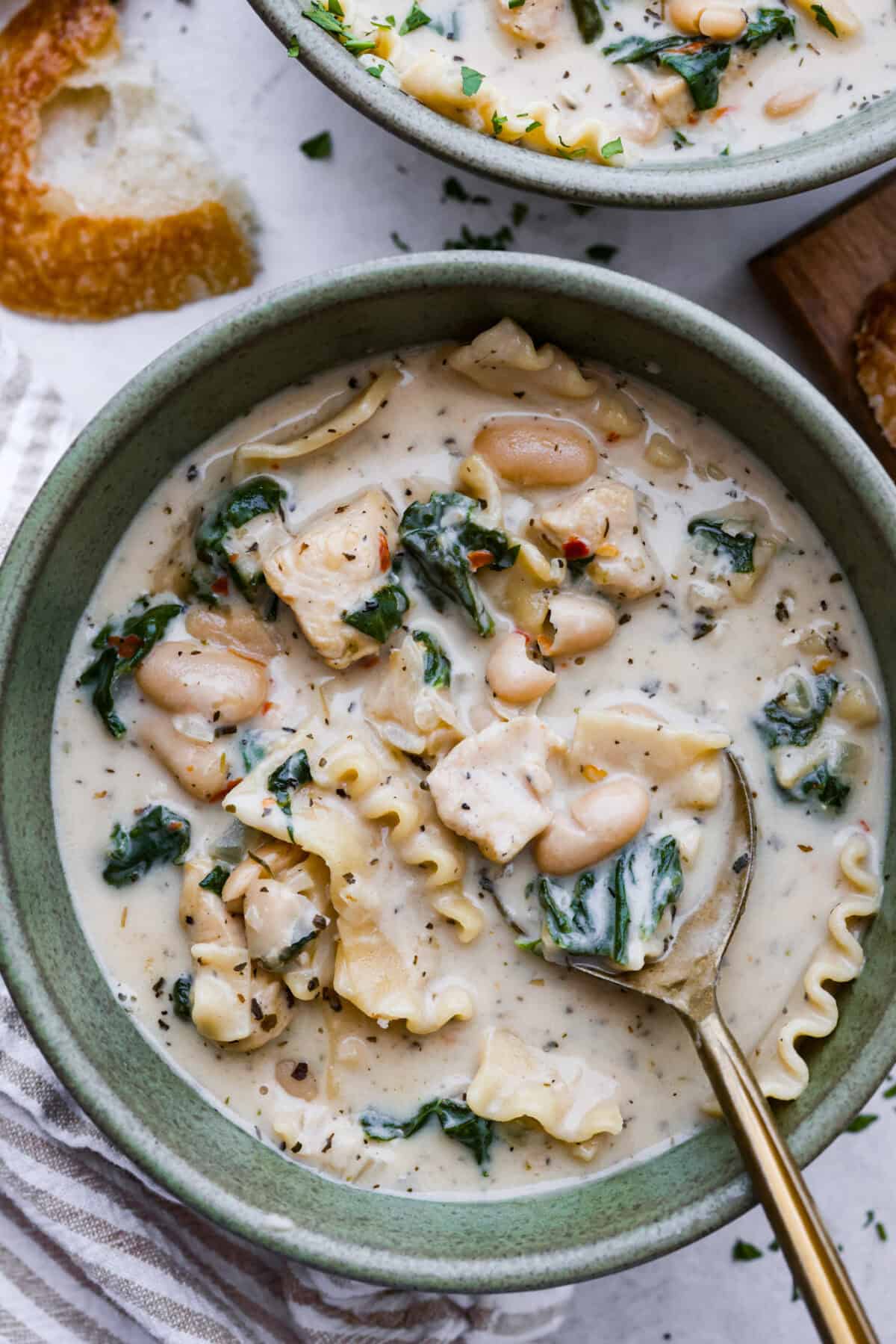 Comforting White Lasagna Soup is warm, creamy, and packed with rich flavors. With its hearty mix of chicken, noodles, white beans, and cheese, it’s a guaranteed crowd-pleaser. Deconstructed white lasagna in a satisfying soup! Overhead shot of a bowl of white lasagna soup.