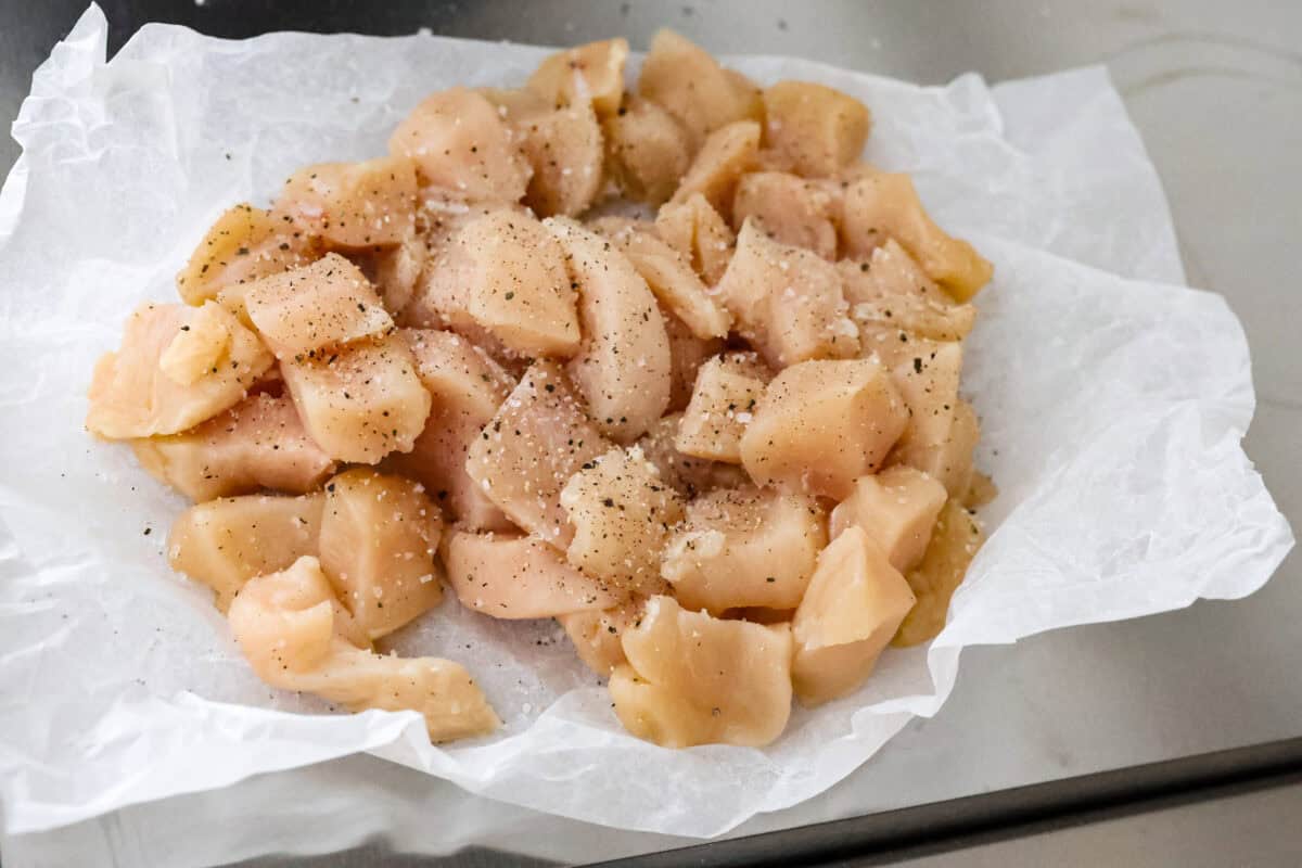 Chicken cordon bleu pasta is a creamy, flavorful dish that's a fun twist on the classic. It combines savory ham, tender chicken, melty cheese, and delicious seasonings. Easy to make and sure to please! Overhead shot of cubed and seasoned chicken pieces.