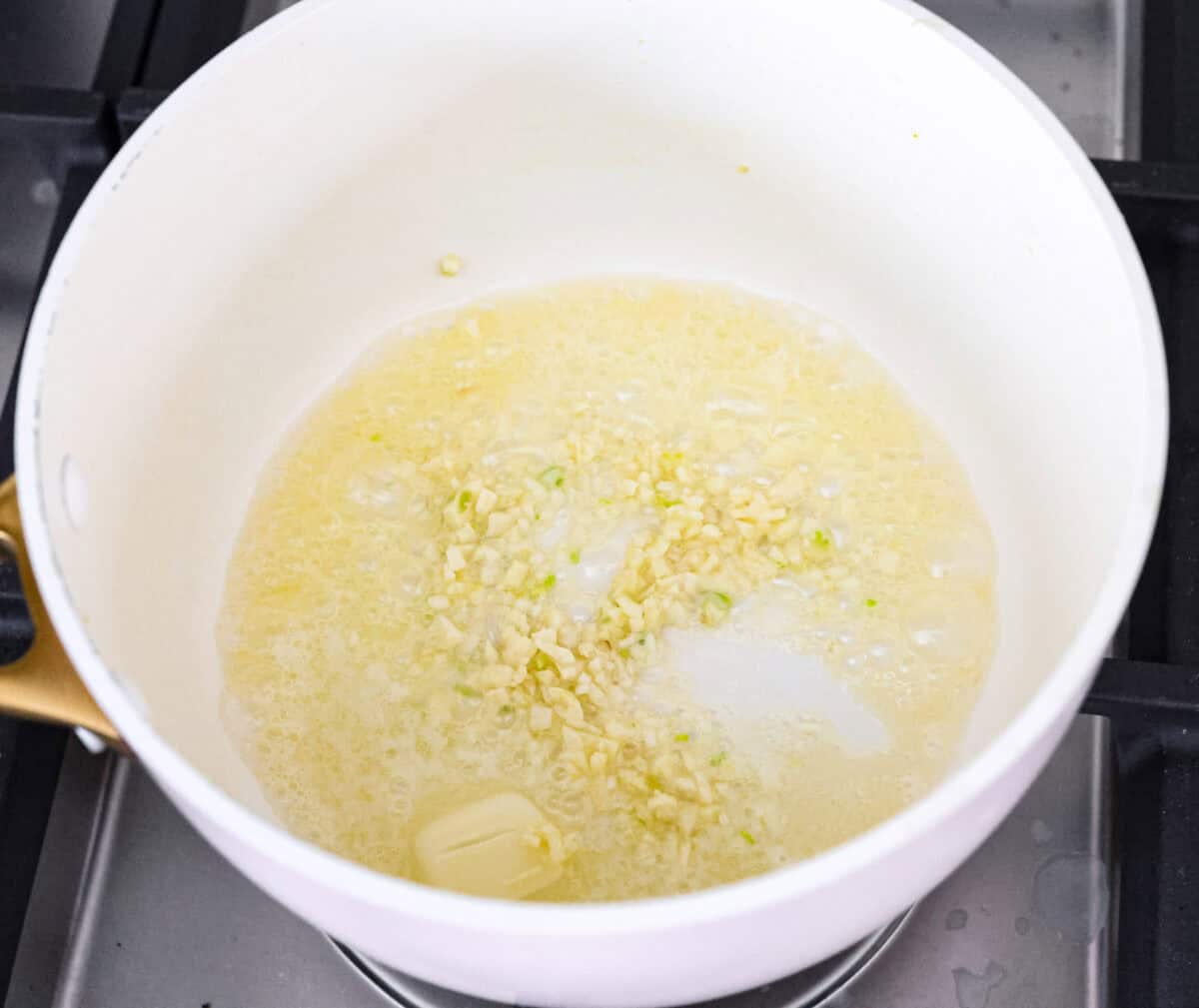 Garlic butter pasta is a quick and simple dish yet packed with flavor. Angel hair pasta is bathed in a buttery garlic sauce and topped with Italian seasoning. Overhead shot of melted butter with garlic in a pot.