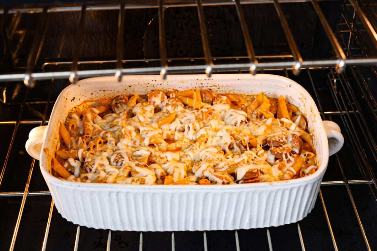 This one-pan Italian Sausage Casserole is the ultimate comfort food! With tender pasta, flavorful sausage, rich marinara, and gooey melted cheese, it’s an easy dinner that’s perfect for busy nights. It's a recipe the whole family will love! Angle shot of pasta dish in the oven.