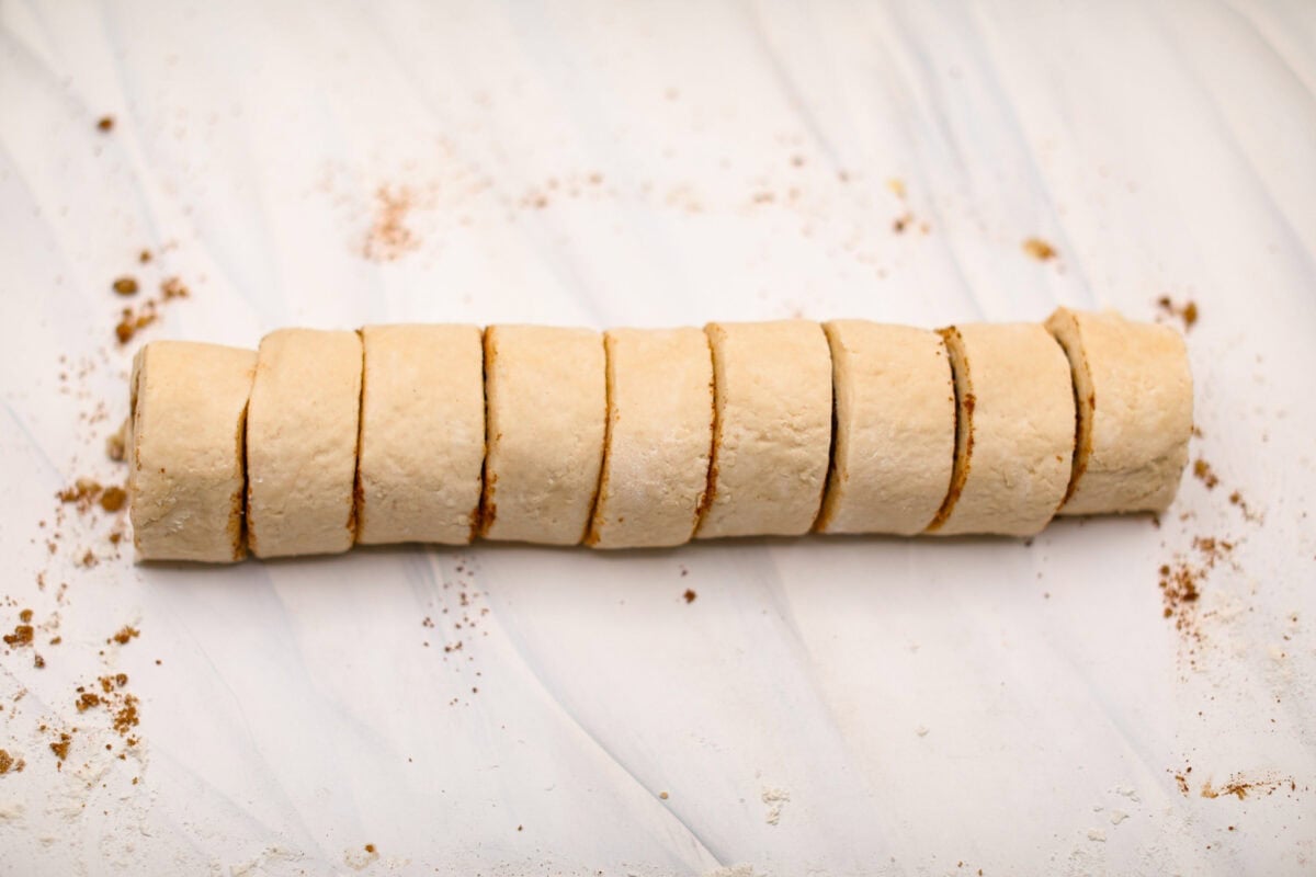 Biscuit Cinnamon Rolls are the most amazing twist on a classic! They are perfectly light, fluffy, and packed with cinnamon. The texture is more flakey and moist than traditional cinnamon rolls! Whether it’s for a cozy weekend breakfast or a holiday brunch, these hit the spot! Overhead shot of cylinder having been cut into individual biscuit cinnamon rolls.