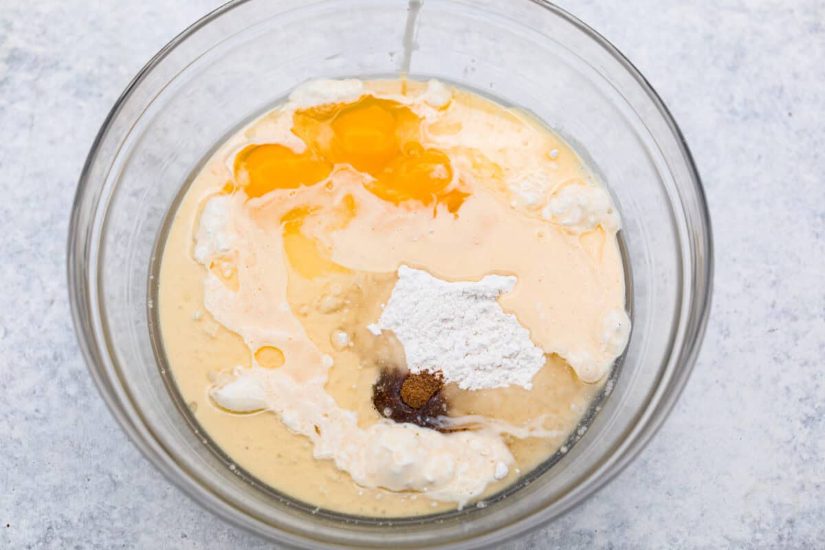 Eggnog Poke Cake could not be more perfect for the holiday season! It combines the rich flavor of eggnog with the soft, moist texture of a classic poke cake. Add fluffy whipped topping and a sprinkle of nutmeg and cinnamon to really wow your family! Overhead shot of cake batter ingredients in a mixing bowl.