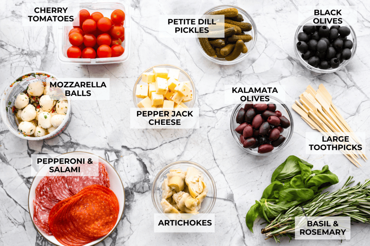 Bring this antipasto charcuterie wreath to your next holiday party! Skewered cheese, deli meats, olives, and pickles shaped into a cute Christmas wreath. A perfect festive appetizer to impress your guests! Ingredients labeled to make antipasto charcuterie wreath.