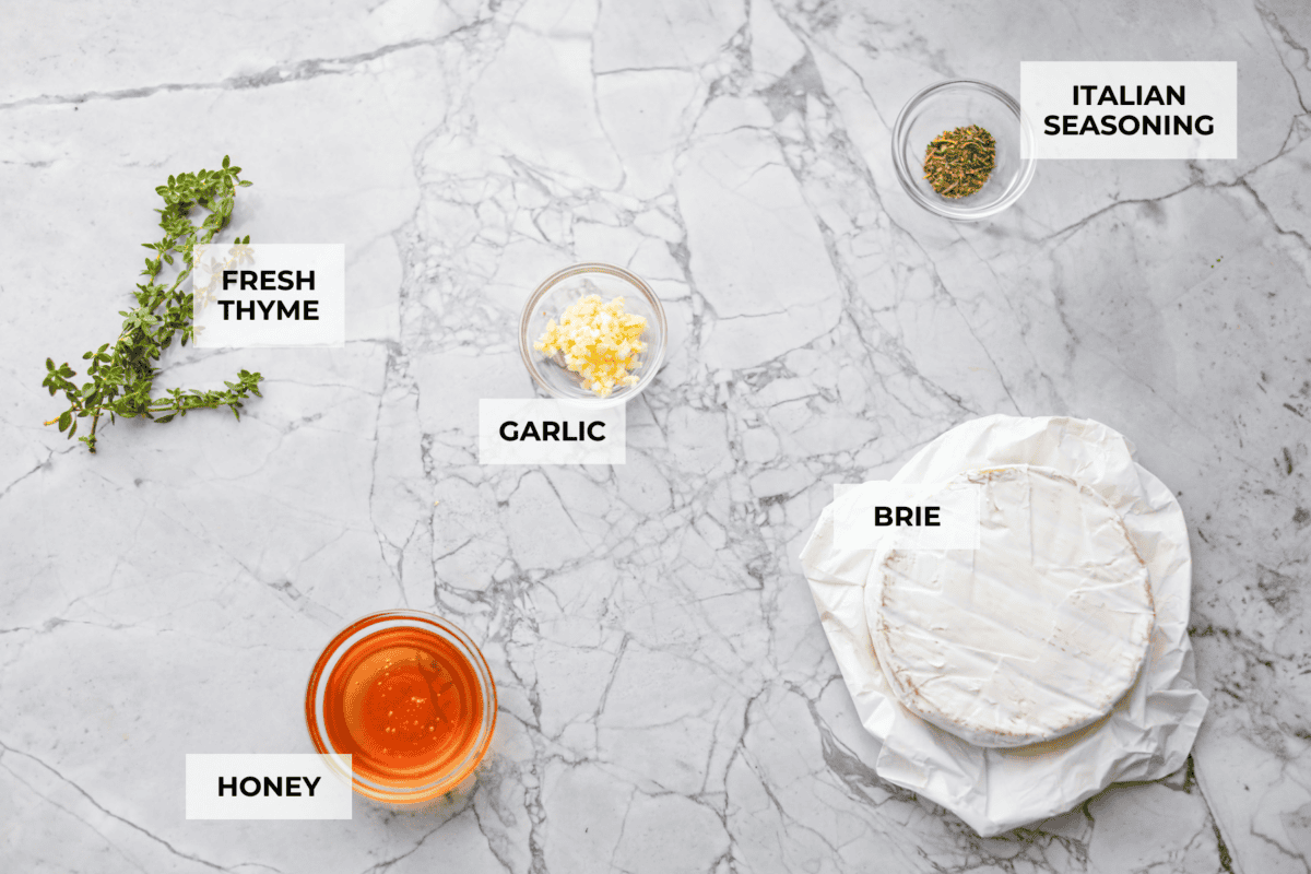 Warm and gooey baked brie is a hit for any occasion! With just five simple ingredients and less than 20 minutes, you will have a rich, creamy appetizer that's impossible to resist. Scoop it up with your favorite crackers or bread! Overhead shot of labeled ingredients.