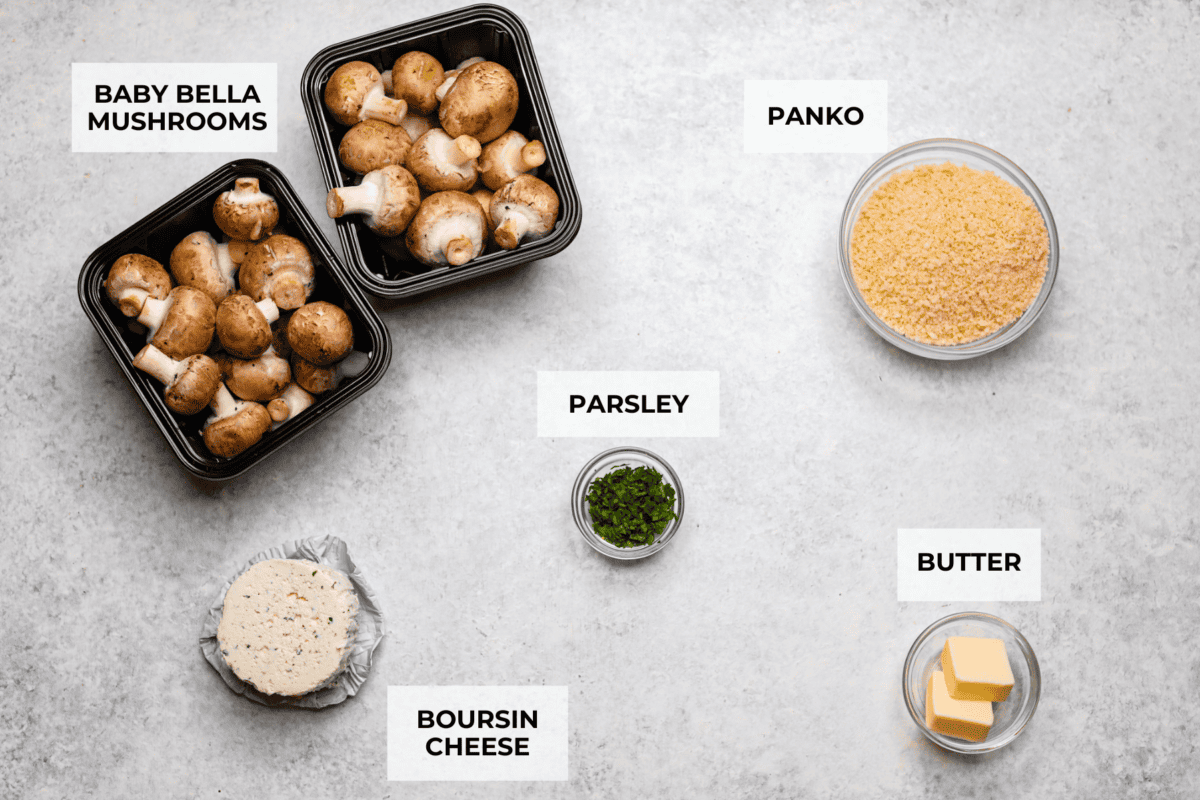 Boursin stuffed mushrooms are a fun, delicious appetizer or side dish. These creamy, cheesy stuffed mushrooms are packed with flavorful Boursin cheese and topped with a delightful breadcrumb crunch. Overhead shot of labeled ingredients.