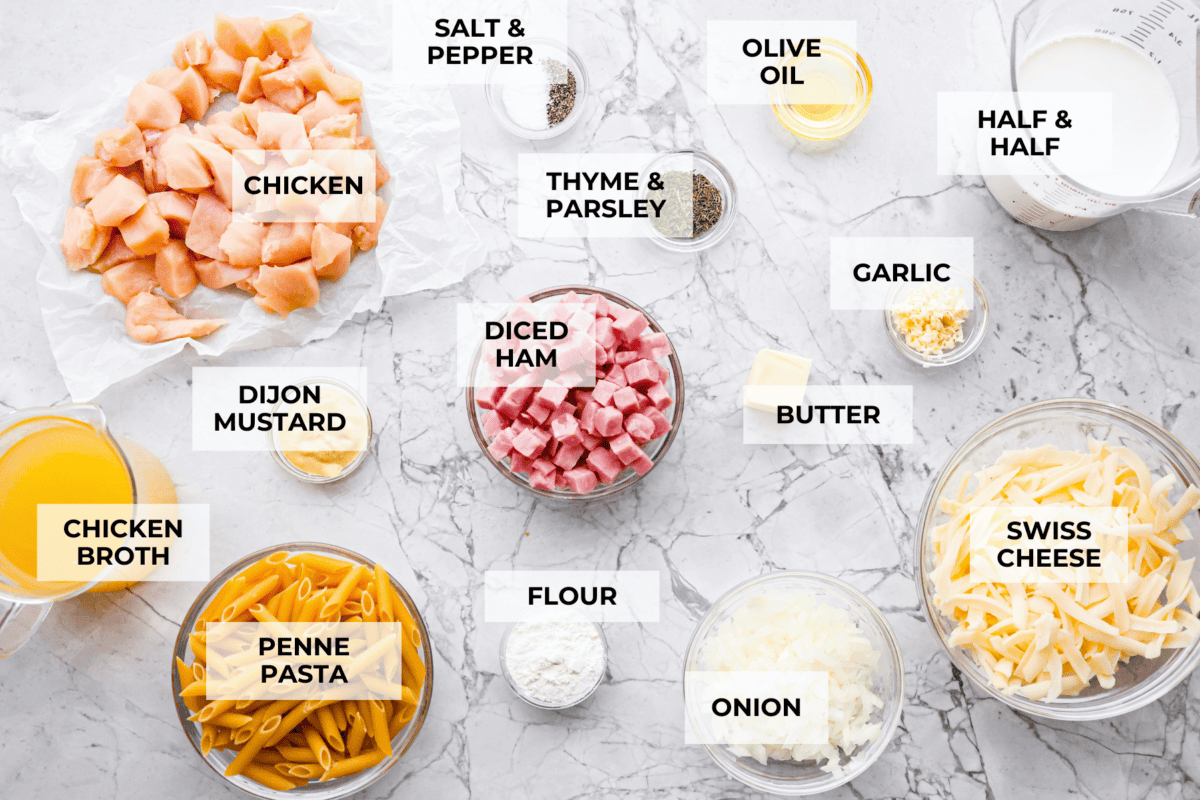 Chicken cordon bleu pasta is a creamy, flavorful dish that's a fun twist on the classic. It combines savory ham, tender chicken, melty cheese, and delicious seasonings. Easy to make and sure to please! Overhead shot of labeled ingredients.