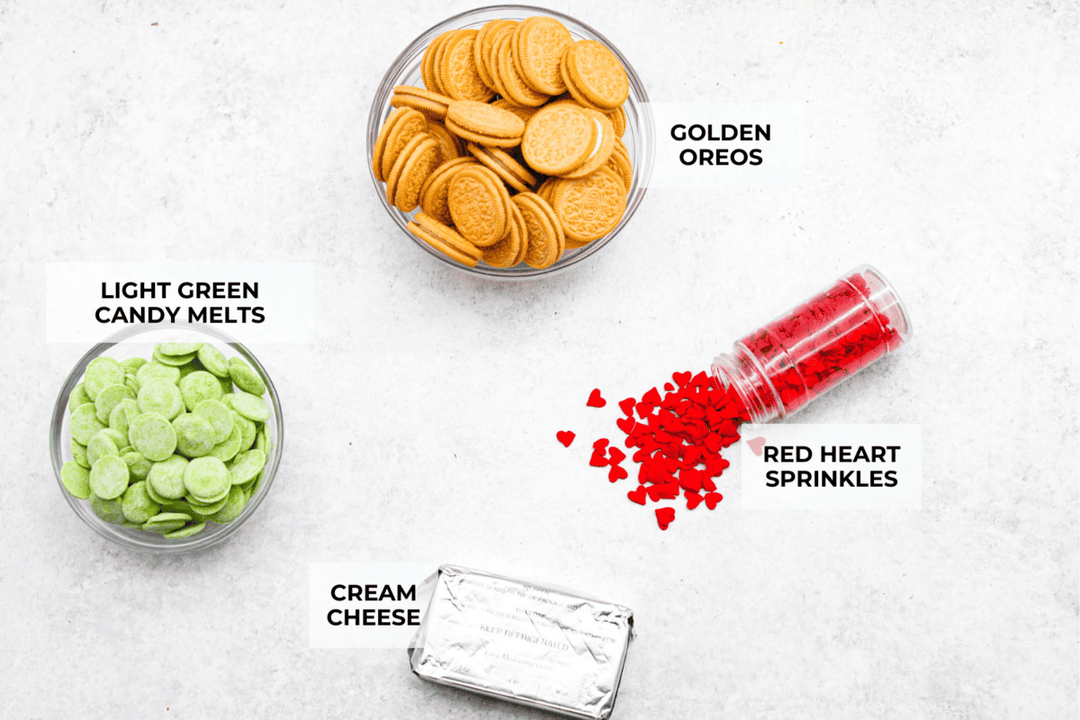 These are the cutest Grinch Oreo balls you have ever seen! Fudgy Oreo filling is coated in green candy melts and garnished with the cutest red heart sprinkle. They taste amazing and will steal the show this holiday season at holiday parties, family get-togethers, or Christmas events. Overhead shot of labeled ingredients.