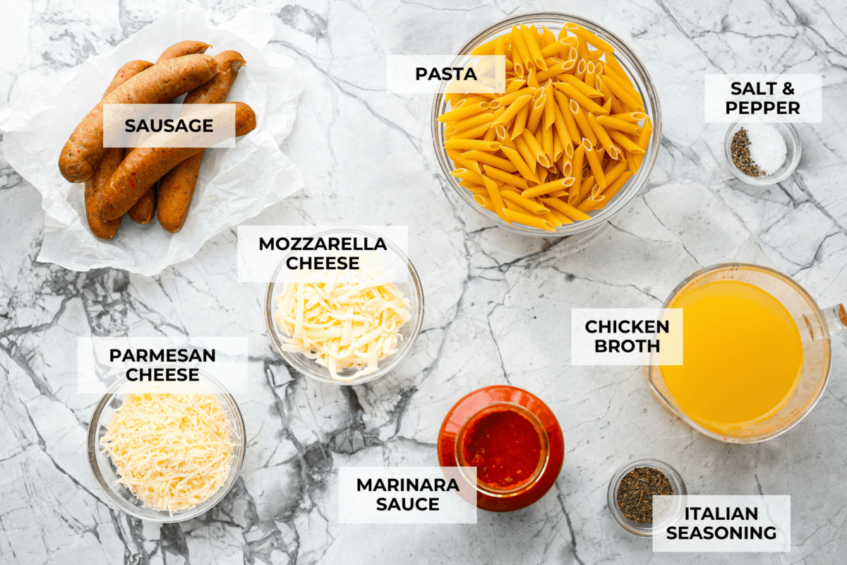 This one-pan Italian Sausage Casserole is the ultimate comfort food! With tender pasta, flavorful sausage, rich marinara, and gooey melted cheese, it’s an easy dinner that’s perfect for busy nights. It's a recipe the whole family will love! Overhead shot of labeled ingredients.