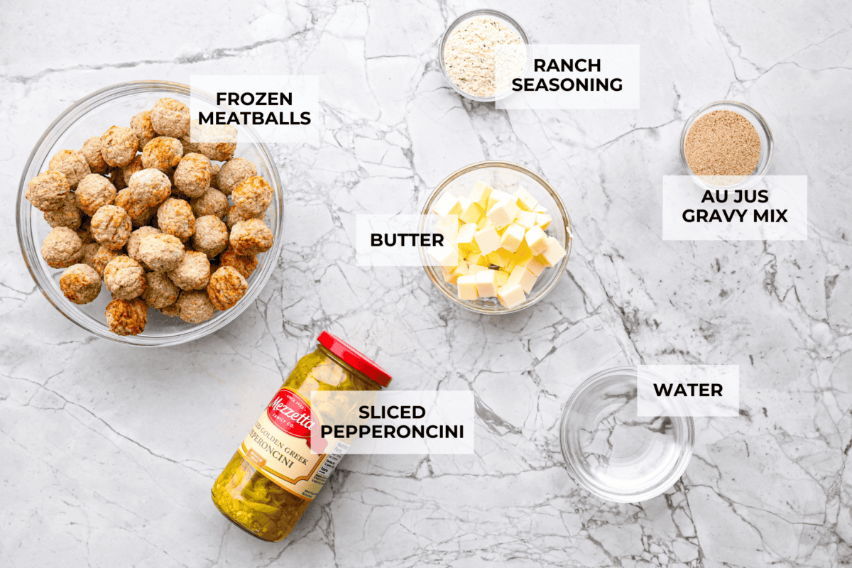 Crockpot Mississippi meatballs make the best little appetizer or side dish. The flavorful pepperoncini mixed with the au jus and ranch seasoning packets with delectable butter makes the most amazing sauce. It's perfectly soaked up by the tender meatballs. Overhead shot of labeled ingredients.