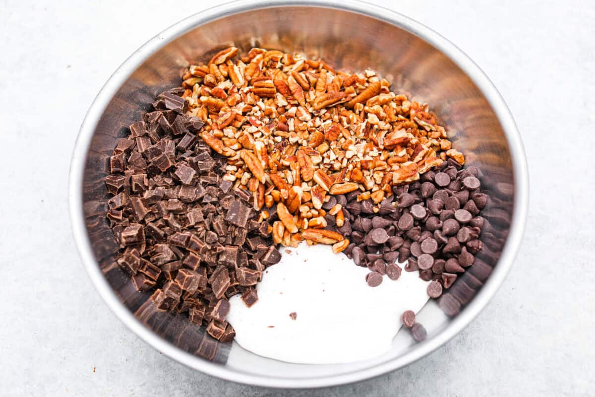 the sugar, butter, salt, and evaporated milk Overhead shot of the chocolate, marshmallow fluff, and pecans in a large bowl.