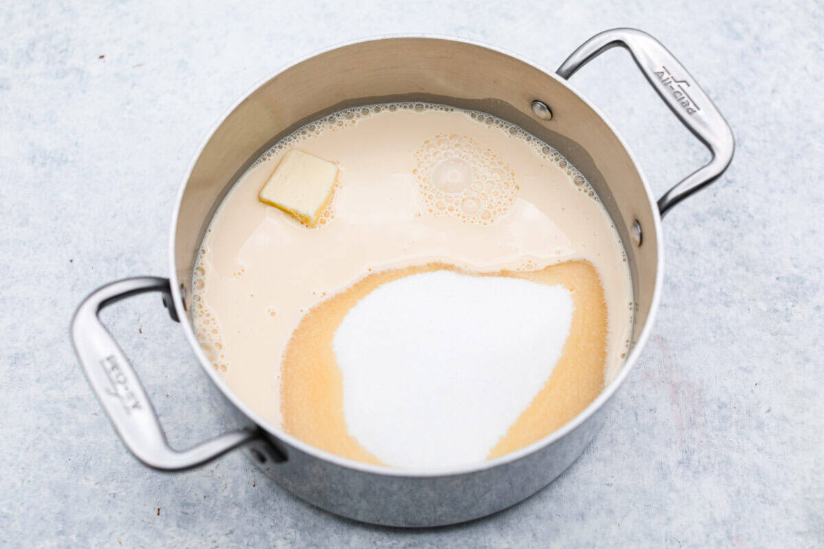 the sugar, butter, salt, and evaporated milk Overhead shot of the sugar, butter, salt, and evaporated milk in a saucepan.