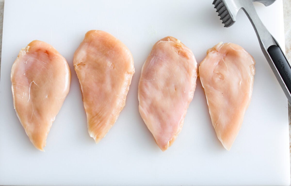 Rosemary Chicken is an incredibly simple yet flavorful dish you can whip up in no time. The infusion of butter with savory shallots, bright lemon juice, fresh rosemary, and tender seared chicken is an explosion of flavor. Overhead shot of tenderized chicken breasts.