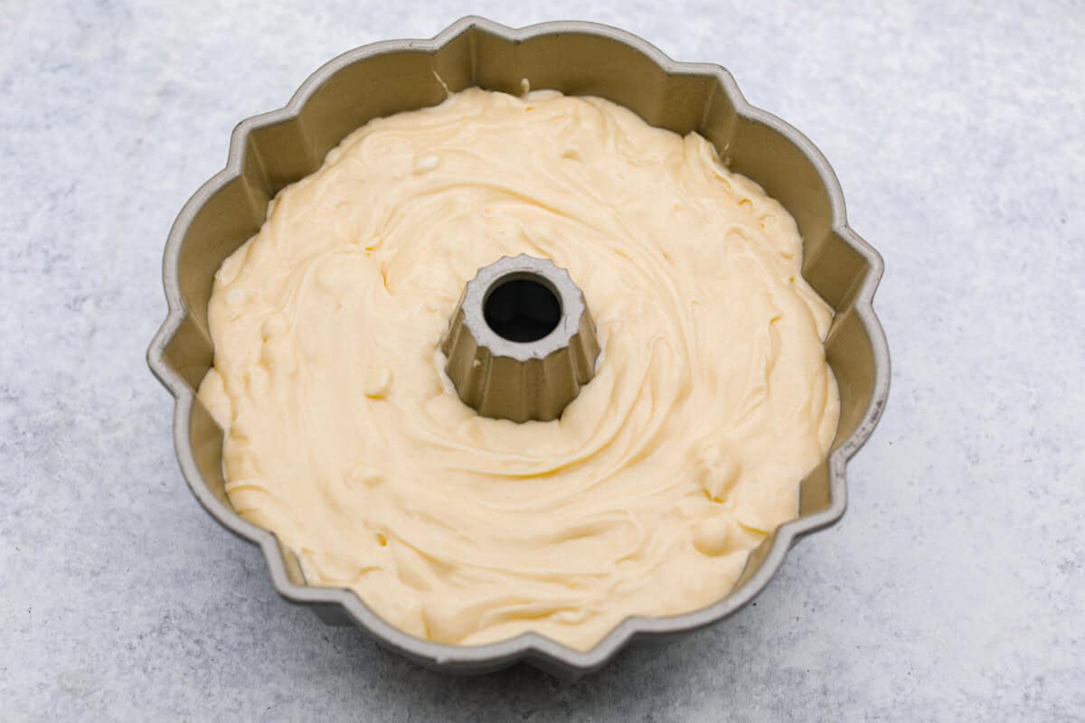 Tom Cruise coconut cake is a dense pound cake with coconut flavor and silky white chocolate throughout. The indulgent frosting is a coconut cream cheese buttercream with sweetened coconut on the outside. It's a coconut lover's dream—but a super sweet one. Overhead shot of the cake batter in the bundt cake.