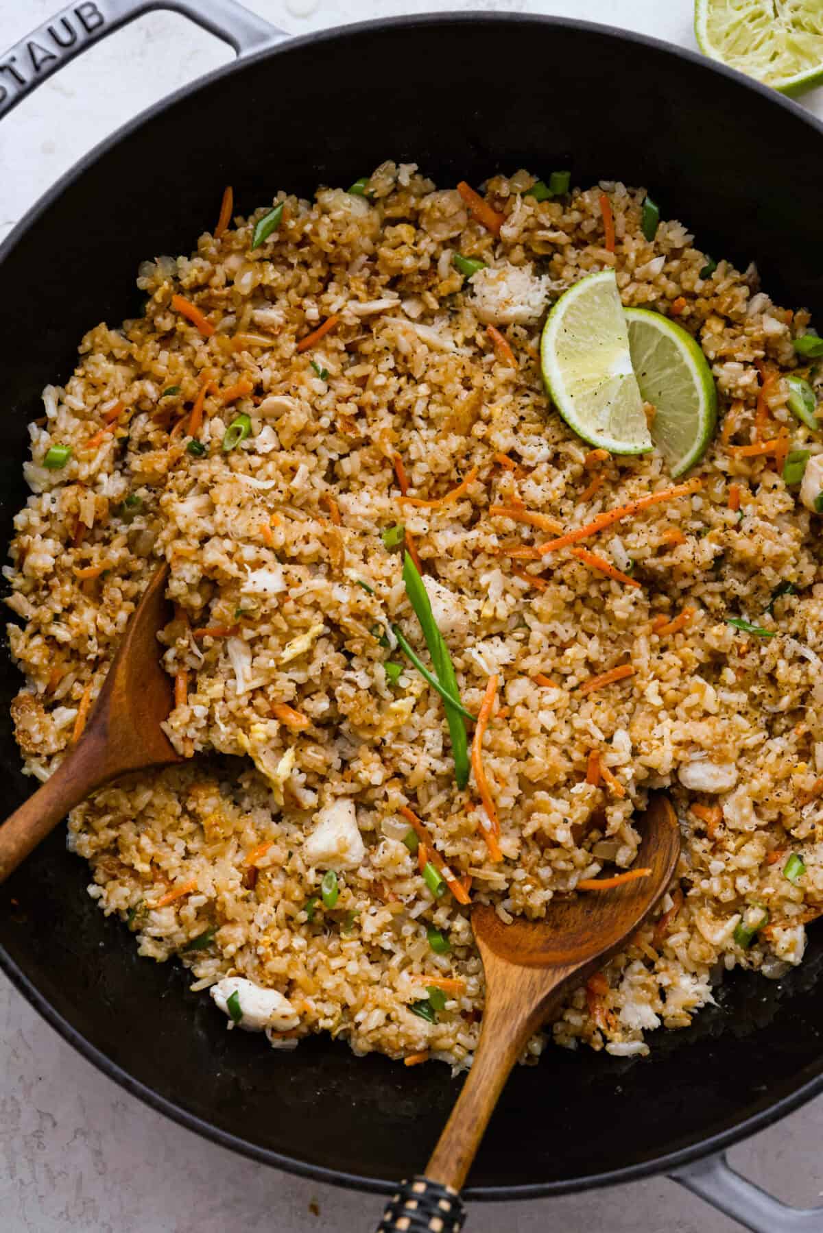 Delicious crab fried rice comes together in just 25 minutes with simple ingredients and tons of flavor! It combines the sweetness of lump crab meat with the savory flavors of classic fried rice for an endlessly satisfying dish that's sure to become a family favorite! Overhead shot of crab fried rice in a wok.