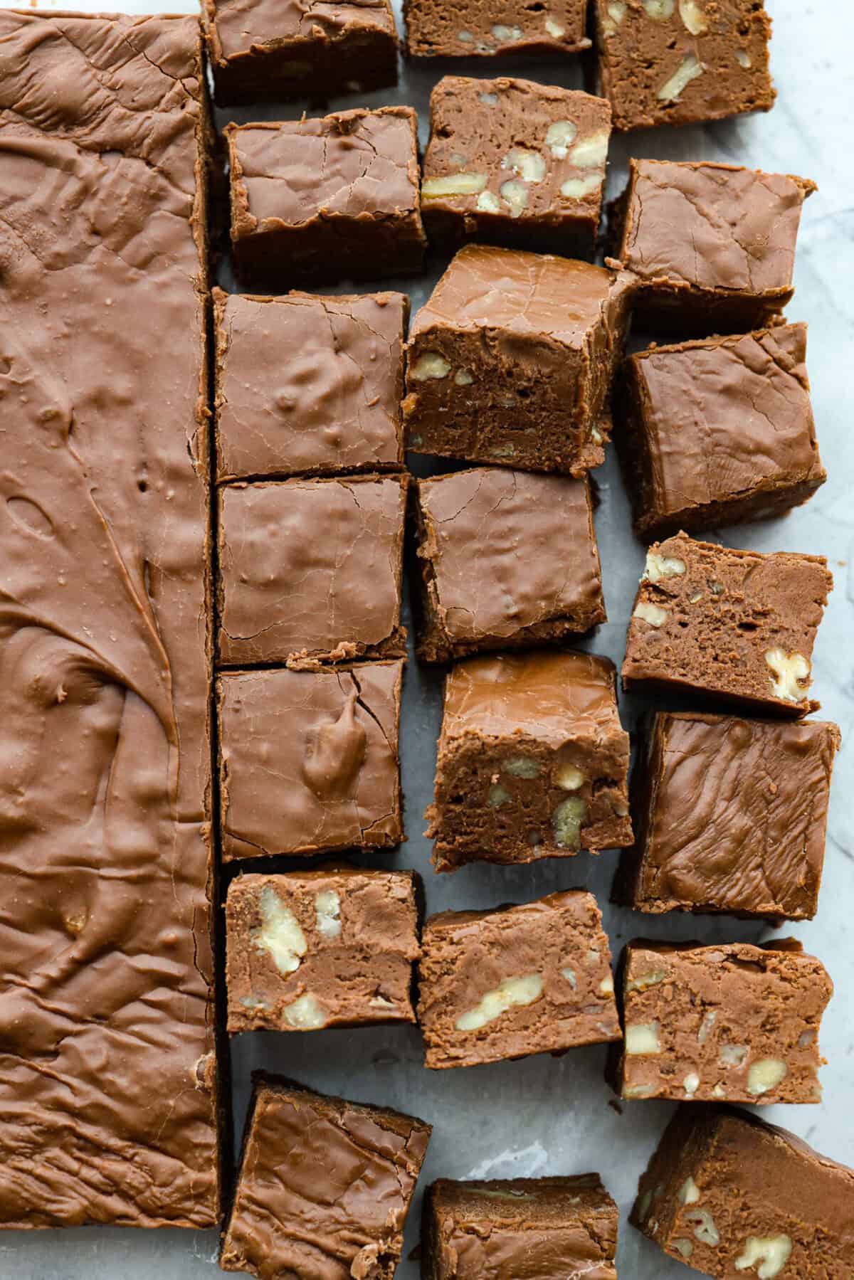 the sugar, butter, salt, and evaporated milk Overhead shot of the brick of fudge cut into pieces with some turned on their side.