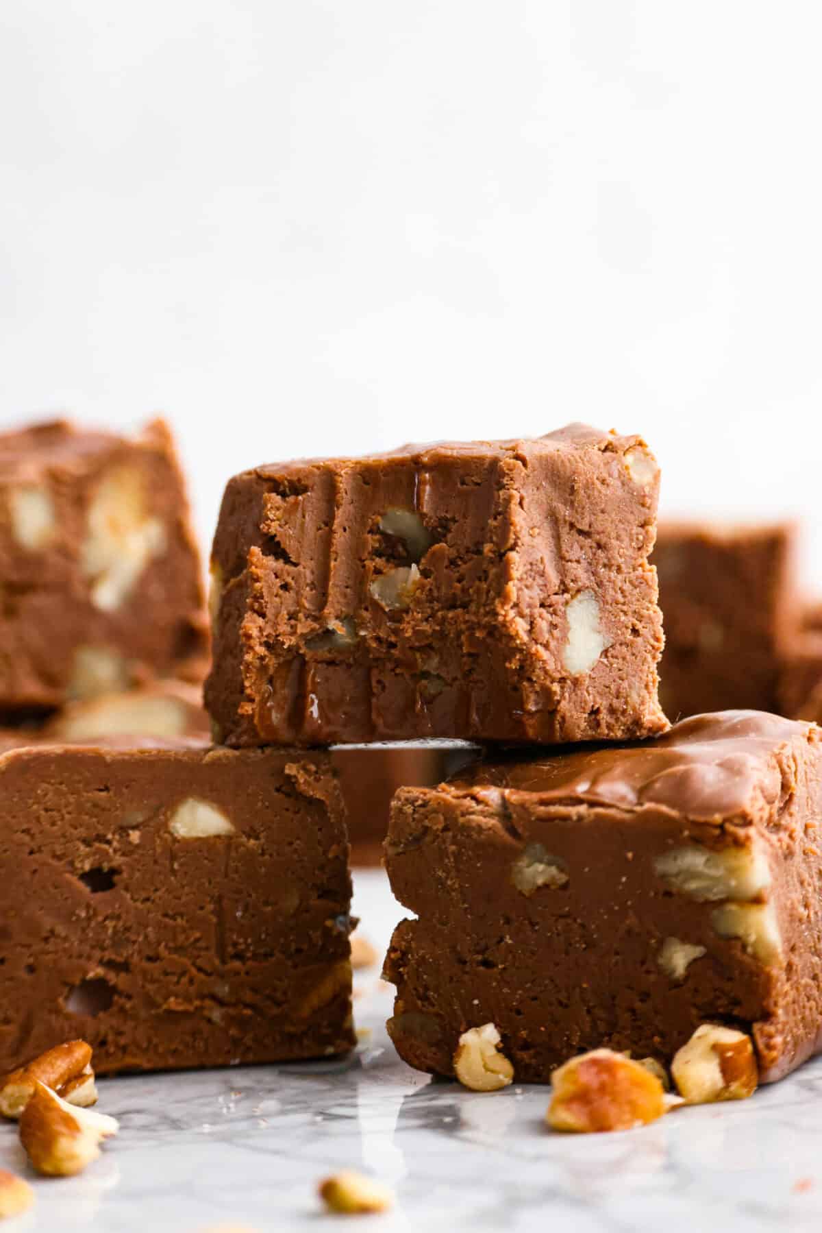 the sugar, butter, salt, and evaporated milk Close up shot of million dollar fudge stacked with a bite taken out of one.