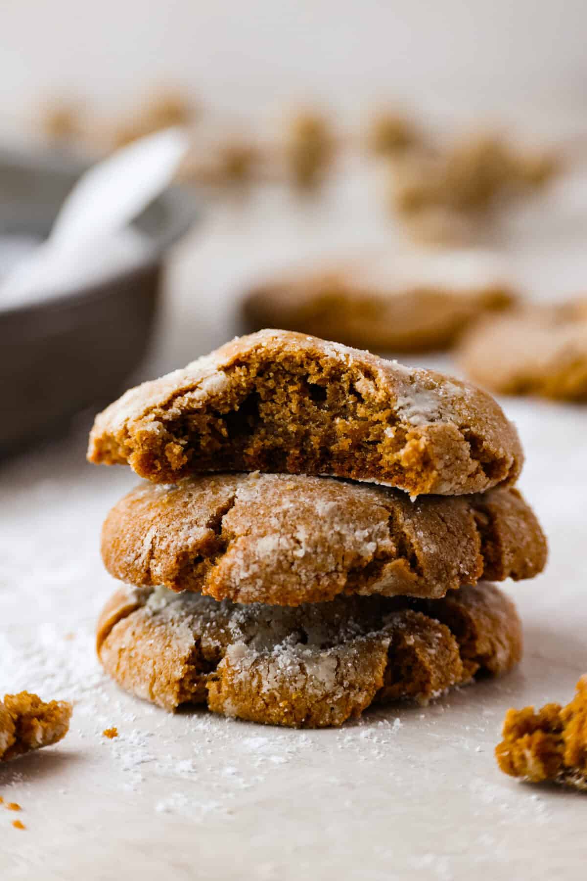 These gingerbread crinkle cookies are incredibly soft and flavorful! Their deep molasses flavor, spiced to perfection and rolled in powdered sugar, is so good with a glass of milk. They are the perfect cookies to make for Santa this holiday season. Side shot of a stack of gingerbread crinkle cookies.