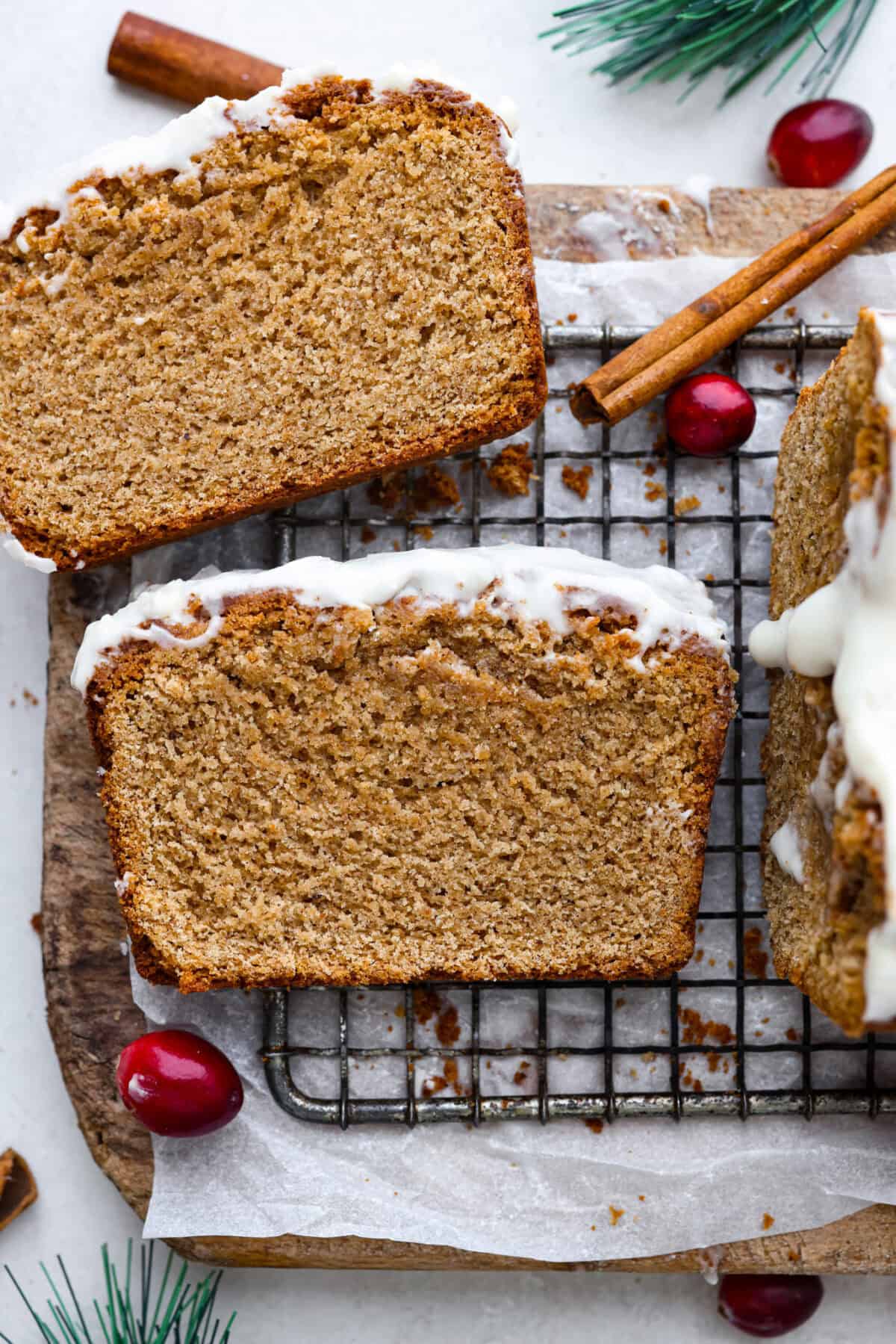Starbucks copycat gingerbread loaf is the ultimate holiday treat! It's coated in a simple cream cheese frosting and is full of warm spices and rich molasses flavor. Enjoy it for Christmas brunch or a sweet treat at night! Overhead shot of gingerbread loaf slices on a cooling rack.