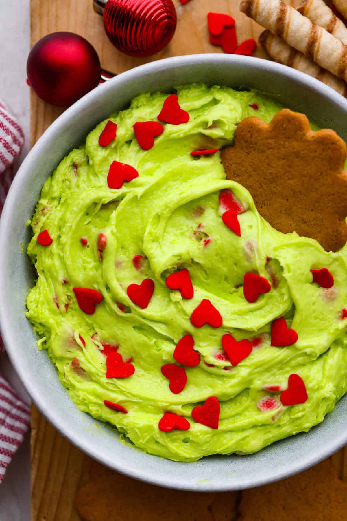 Grinch dip is a sweet and scrumptious dip perfect for any holiday party or gathering. It combines delicious cake mix, fluffy whipped topping, and smooth yogurt or pudding to create a fun dip for cookies, treats, or fruit. Close up shot of Grinch dip.