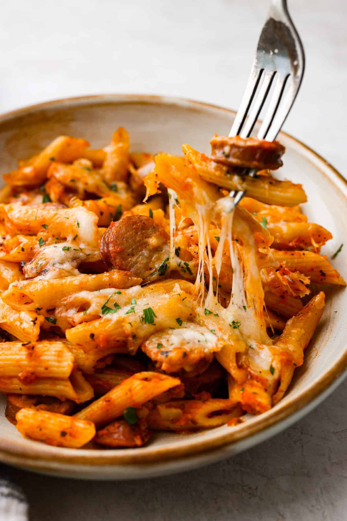 This one-pan Italian Sausage Casserole is the ultimate comfort food! With tender pasta, flavorful sausage, rich marinara, and gooey melted cheese, it’s an easy dinner that’s perfect for busy nights. It's a recipe the whole family will love! Close up shot of plated Italian sausage casserole.