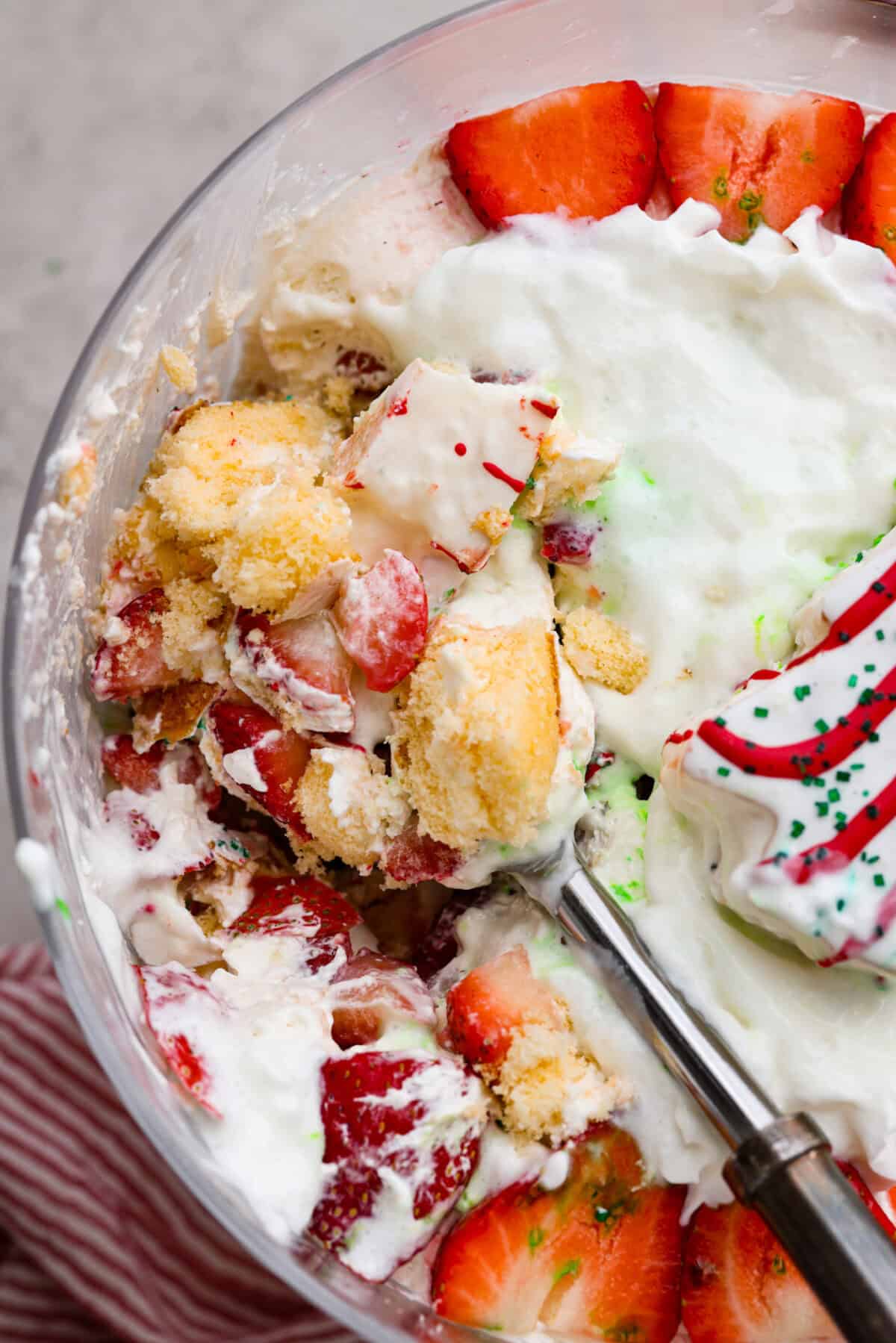 Little Debbie Christmas tree trifle is super adorable and tastes amazing! It's filled with sweet strawberries, creamy cream cheese, whipped topping flavored fluff, and chunks of the iconic Little Debbie Christmas trees. Close up shot of Little Debbie Christmas tree trifle.