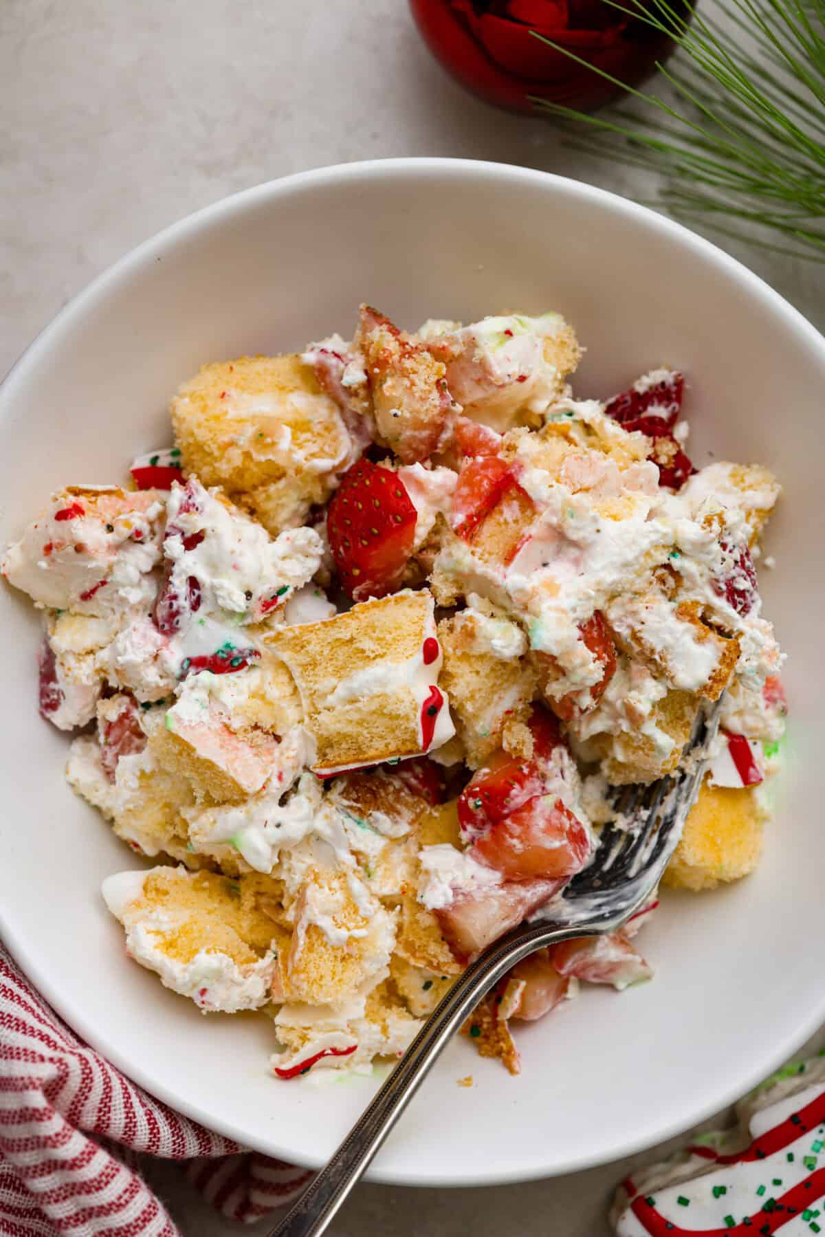 Little Debbie Christmas tree trifle is super adorable and tastes amazing! It's filled with sweet strawberries, creamy cream cheese, whipped topping flavored fluff, and chunks of the iconic Little Debbie Christmas trees. Overhead shot of a bowl of Little Debbie Christmas tree trifle.