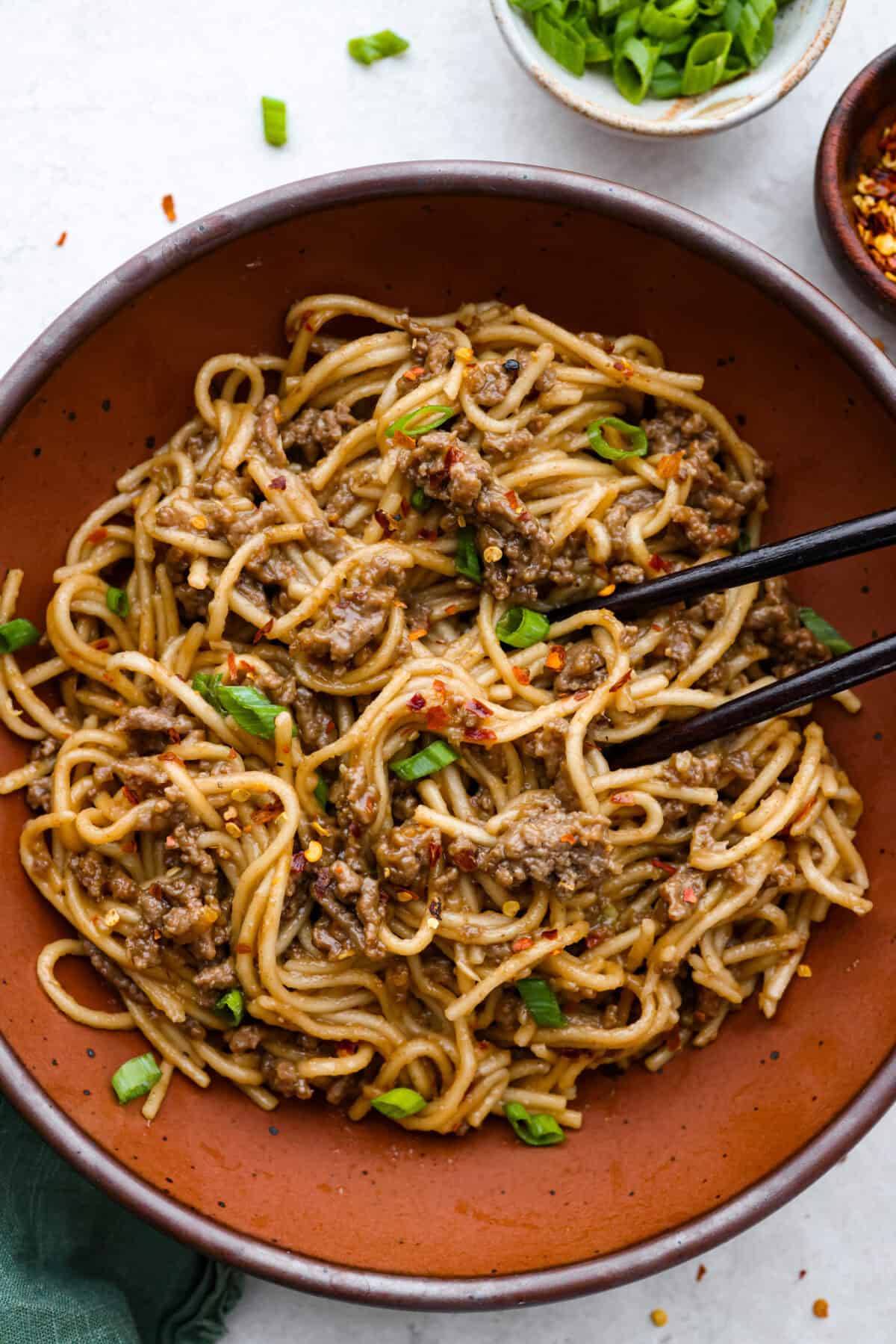Mongolian Ground Beef and Noodles is a flavorful dinner that’s ready in 30 minutes! This dish combines tender noodles, savory ground beef, and a sweet and tangy Asian-inspired sauce for a meal that’s as comforting as it is delicious! Close up shot of Mongolian ground beef and noodles.