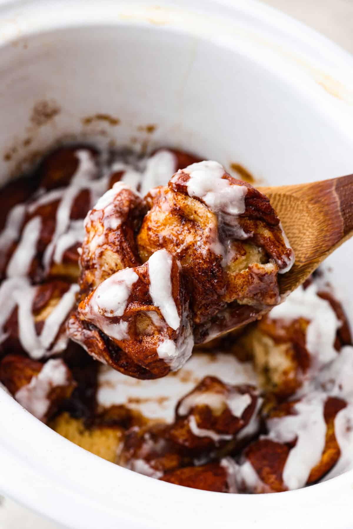 Crockpot monkey bread is an easy, gooey treat made in your slow cooker. It’s packed with soft biscuit pieces, cinnamon-sugar flavor, and a sweet buttery glaze. No oven needed! Close up shot of a scoop of crockpot monkey bread from the slow cooker.