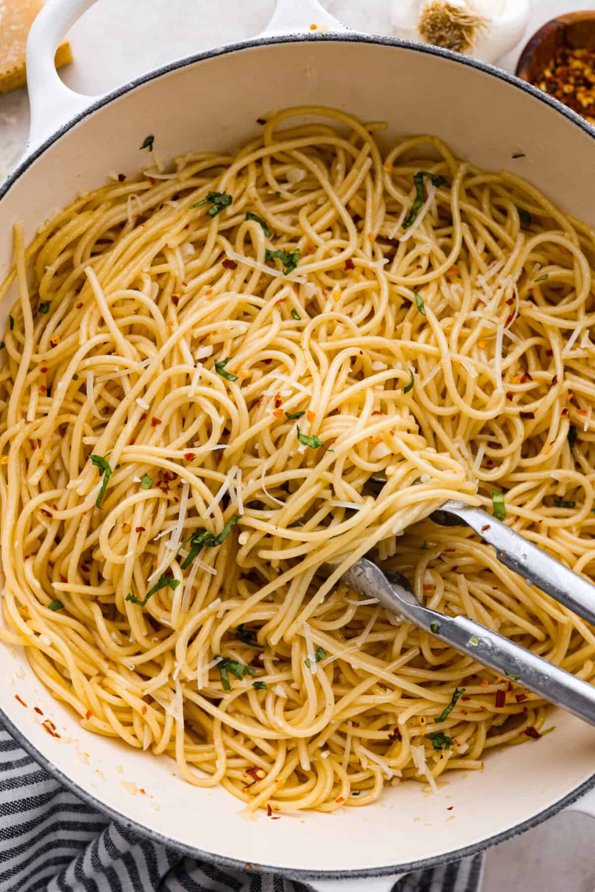Spaghetti Aglio e Olio uses simple ingredients to create a dish bursting with flavor! With just garlic, olive oil, chili flakes, pasta, and parmesan cheese, this classic Italian recipe is a go-to for a tasty meal in less than 30 minutes. Overhead shot of spaghetti aglio e olio in a pot.