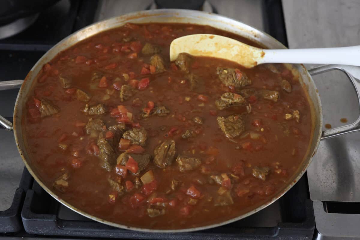 Comforting beef curry is a perfect blend of hearty and flavorful! With its mild spice level, it’s a dish that everyone can enjoy, but you can easily turn up the heat with a pinch of red pepper. Pair it with rice or naan for the ultimate cozy dinner! Angle shot of the finished dish simmering on the stove top.