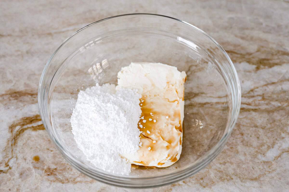 Craving the buttery goodness of a Starbucks cream cheese Danish? Now you can make it right at home! This easy copycat recipe uses flaky puff pastry and a sweet, creamy cheese filling for a treat that’s just as delicious, maybe even better! Overhead shot of cream cheese, powdered sugar and vanilla extract in a mixing bowl.