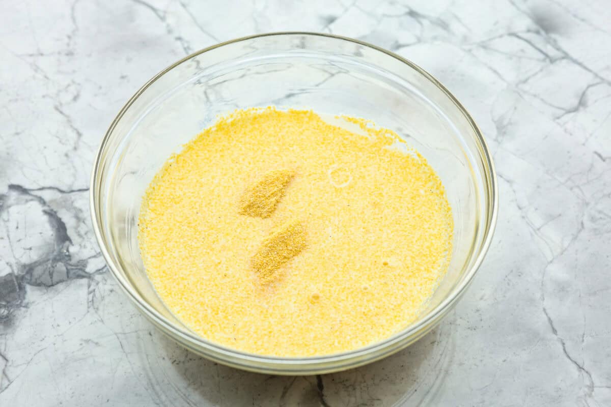 Spoon bread is a beloved classic Southern side dish. It’s similar to cornbread but is less sweet and has a softer, almost soufflé-like texture. This unique bread is best enjoyed warm with a dollop of butter, a drizzle of honey or served alongside a hearty bowl of chili. Overhead shot of milk and cornmeal mixed in a bowl.