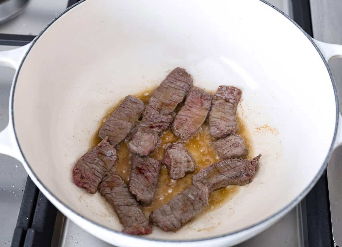 This simplified version of Vietnamese noodle soup brings the comforting flavors you love in Pho but with less effort. For a truly authentic experience, donโt miss out on this detailed recipe! Overhead shot of beef searing in sesame oil in a pot.