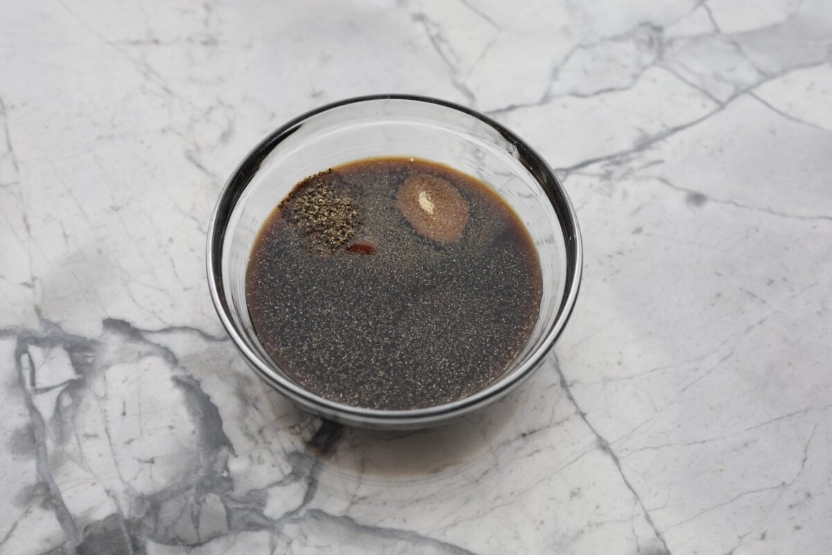 This A-1 copycat homemade steak sauce recipe is slightly sweet with a delicious tang from the vinegar. It's perfect for drizzling over your favorite cut of tender, juicy meat. Overhead shot of all of the ingredients in a bowl.