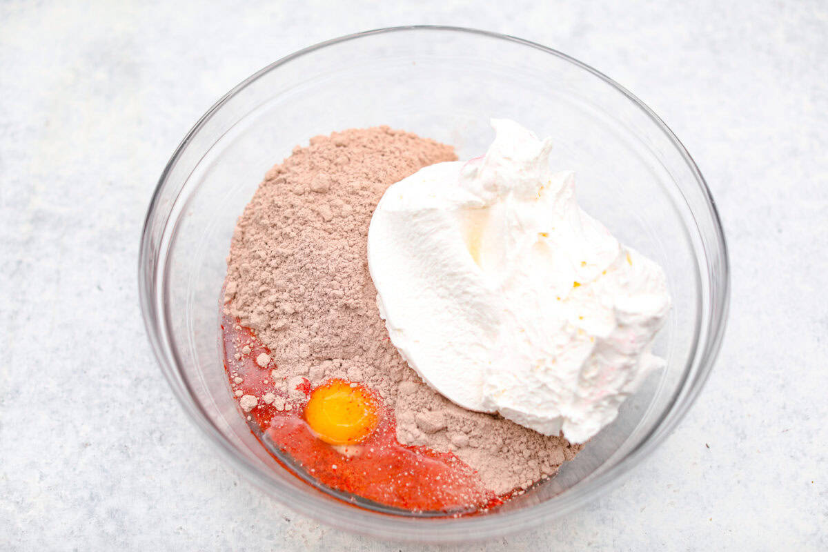 Gorgeous Cool Whip Cookies are made with just 4 simple ingredients! They bake up soft, fluffy, and bursting with flavor. Perfect for last-minute treats or when you’re craving something sweet without the fuss! Overhead shot of cake mix, egg and cool whip in a mixing bowl.